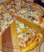 Пицца с чёрным кунжутом, сыром, беконом, курицей и ветчиной